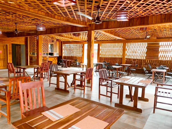 Wooden-finished indoor dining and event hall with tables and chairs